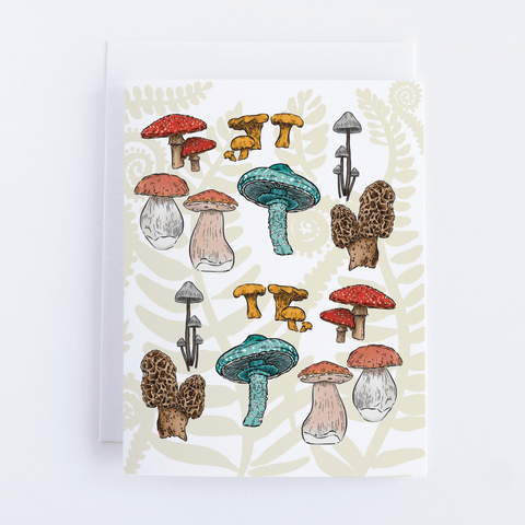 The Mushroom Forest Greeting Card featuring a patten made of a variety of colorful mushrooms on a pale fern design background. Card is laid on a white background.